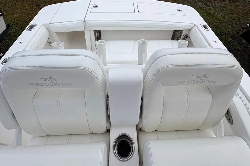 Slide: The Image of 2021 Regulator 28 Forward Seating boat with white leather seats and cup holders. - 9