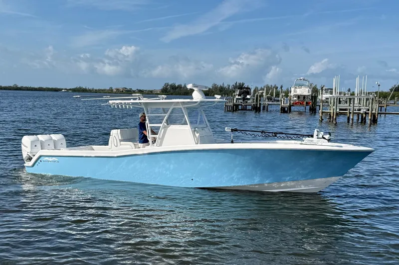 The Image of 2021 Invincible 36 CC boat cruising on a sunny day near a marina. - 1
