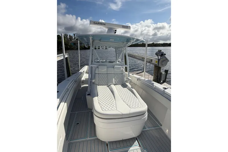 Slide: The Image of 2021 Invincible 36 CC boat with cushioned seating and Garmin equipment, docked by the water. - 11