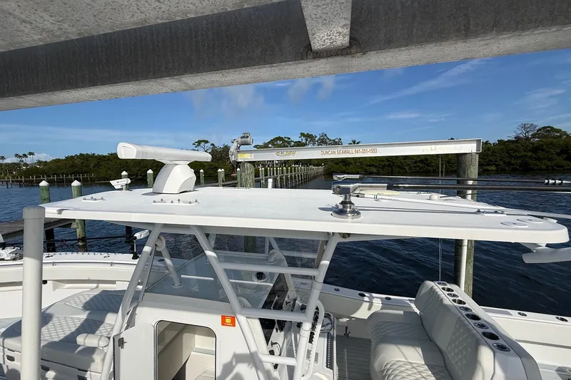 Slide: The Image of 2021 Invincible 36 CC boat docked, featuring sleek design and spacious seating. - 12