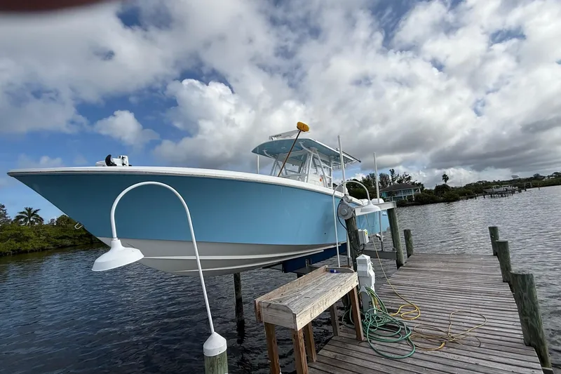 Slide: The Image of 2021 Invincible 36 CC boat docked on a wooden pier under cloudy skies. - 15