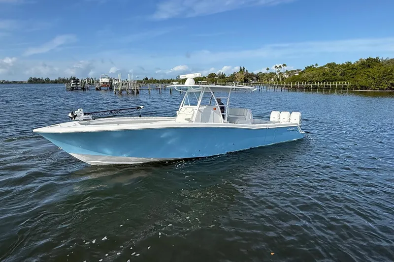 Slide: The Image of 2021 Invincible 36 CC boat on calm water, clear sky background. - 20