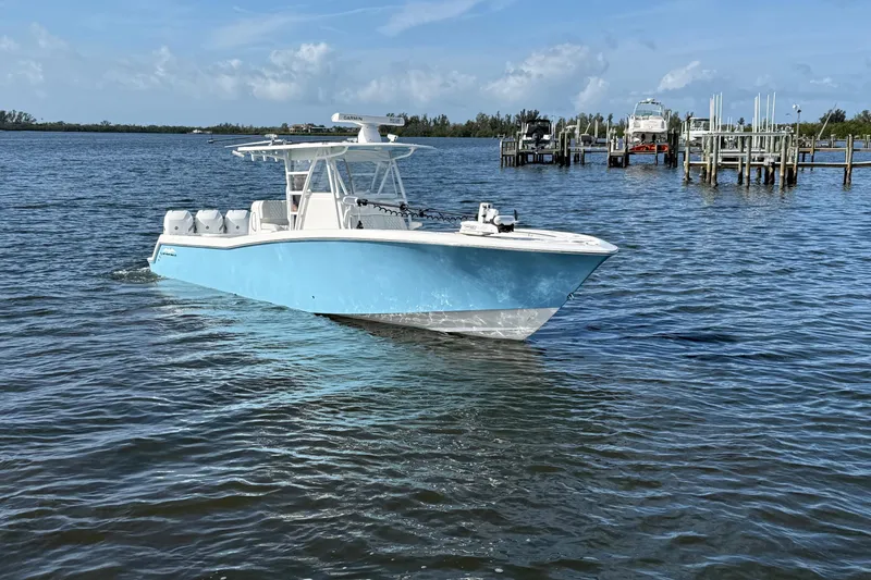 Slide: The Image of 2021 Invincible 36 CC boat on calm water, clear sky background. - 22