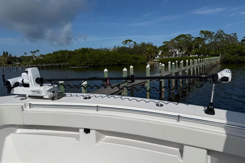 Slide: The Image of 2021 Invincible 36 CC boat with Minn Kota trolling motor, docked near lush greenery. - 3