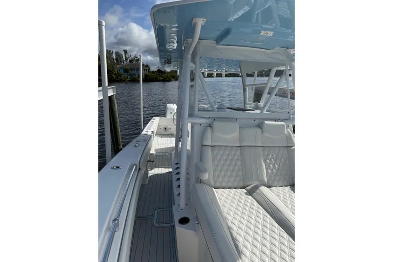 Slide: The Image of 2021 Invincible 36 CC boat with white seating and sleek design on a calm waterway. - 4