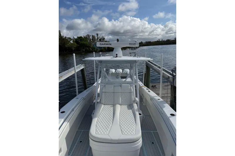 Slide: The Image of 2021 Invincible 36 CC boat docked, featuring Garmin equipment under a cloudy sky. - 5