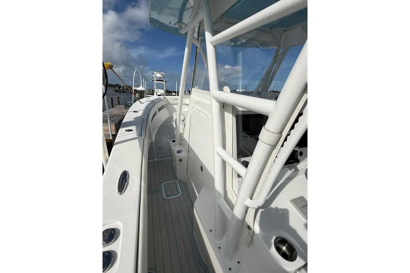 Slide: The Image of 2021 Invincible 36 CC boat docked, showcasing sleek design and spacious deck. - 9