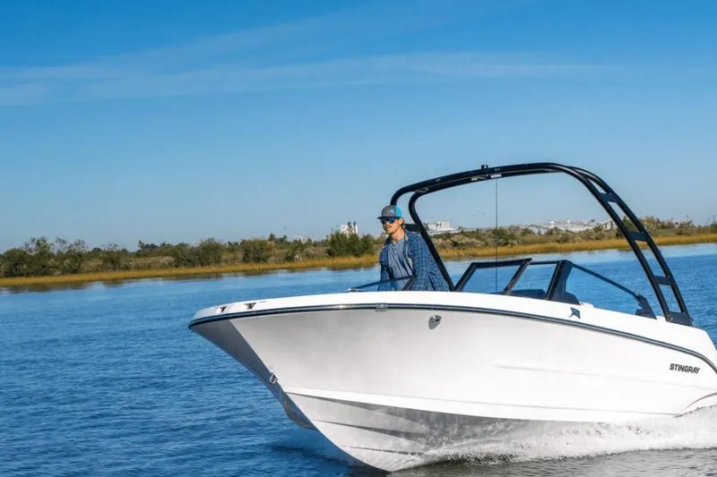 Slide: The Image of 2026 Stingray 20 SBX boat cruising on a sunny day, with a clear blue sky. - 5