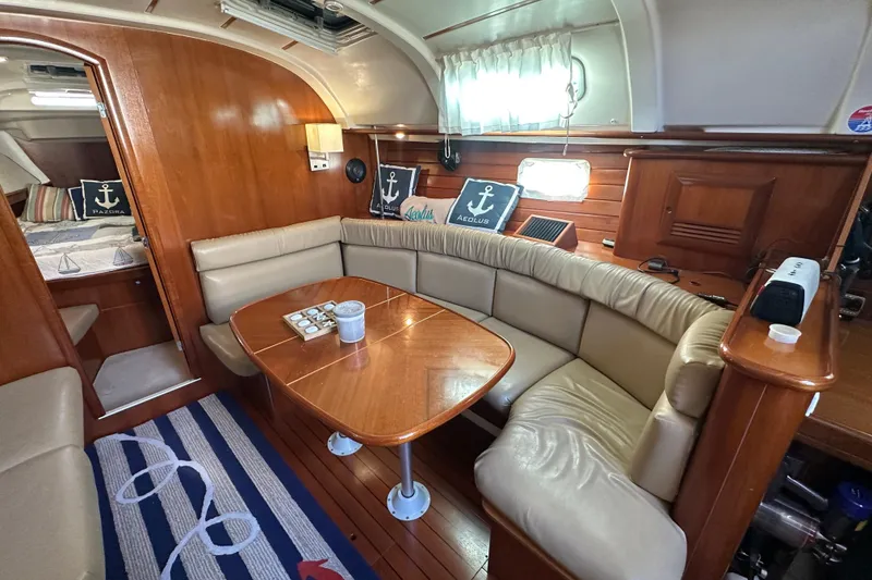 Slide: The Image of Interior of 2001 Beneteau 381 yacht with cozy seating and nautical decor. - 18