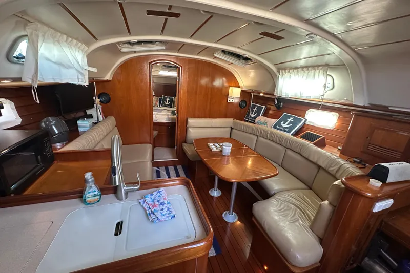 Slide: The Image of Luxurious interior of 2001 Beneteau 381 sailboat with cozy seating and wooden finishes. - 24