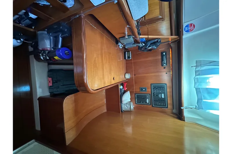 Slide: The Image of Interior of 2001 Beneteau 381 sailboat with wooden cabinetry and control panels. - 26