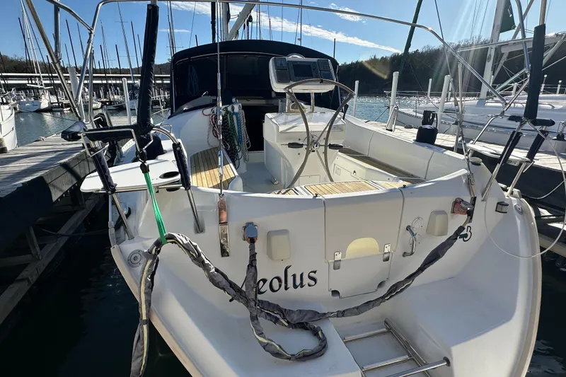 Slide: The Image of 2001 Beneteau 381 sailboat docked at marina, featuring spacious cockpit and steering wheel. - 6