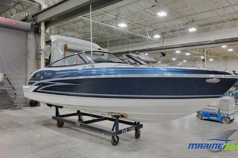 The Image of 2026 Formula 240 Bowrider boat in a showroom, blue and white design. - 0