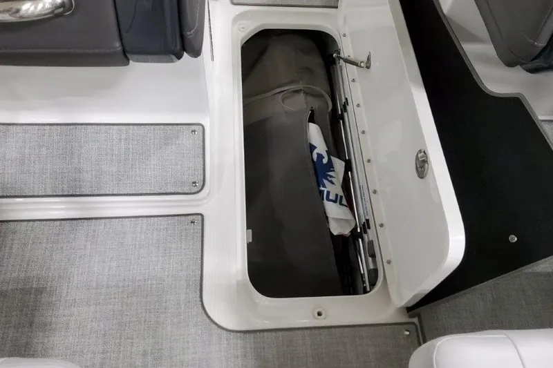 Slide: The Image of 2026 Formula 240 Bowrider storage compartment with gray flooring and open hatch. - 13