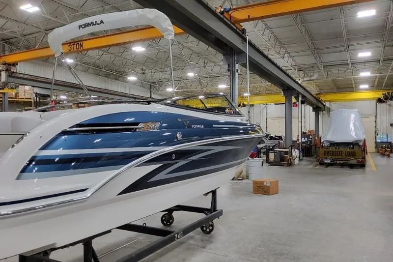 Slide: The Image of 2026 Formula 240 Bowrider boat in a spacious indoor facility. - 2
