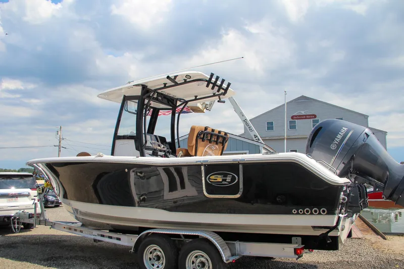 The Image of 2022 Sea Hunt Gamefish 25 boat on trailer, featuring Yamaha outboard motor. - 0