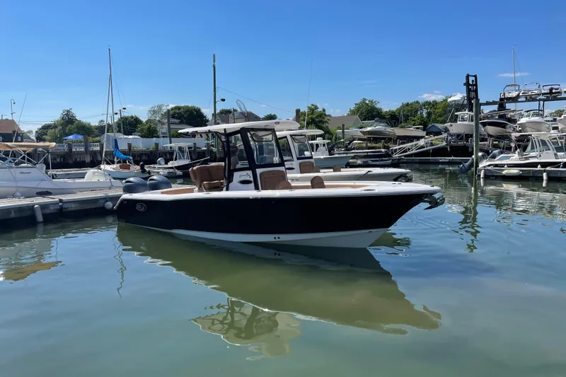 Slide: The Image of 2022 Sea Hunt Gamefish 25 boat docked in a marina under clear blue skies. - 2