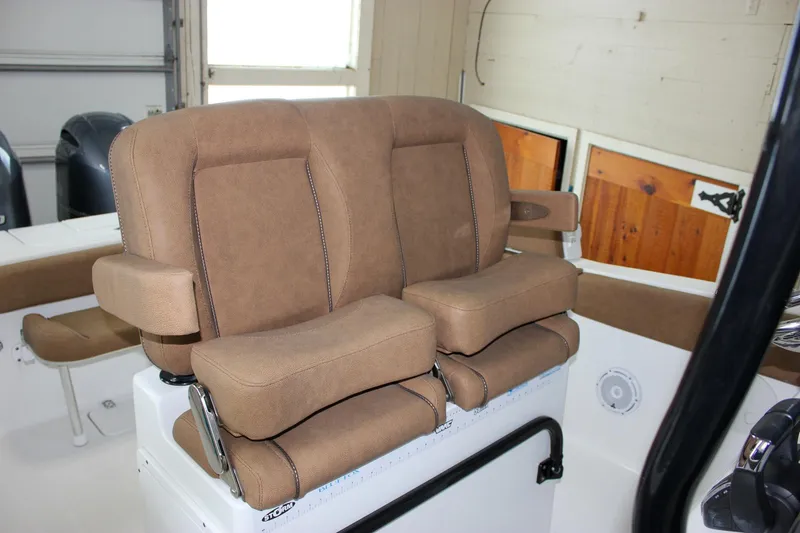 Slide: The Image of 2022 Sea Hunt Gamefish 25 boat with tan cushioned seating in cabin. - 27