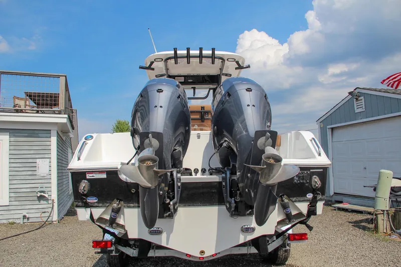 Slide: The Image of 2022 Sea Hunt Gamefish 25 with dual outboard motors, parked outdoors. - 3