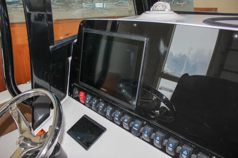 Slide: The Image of 2022 Sea Hunt Gamefish 25 dashboard with steering wheel and electronic controls. - 36