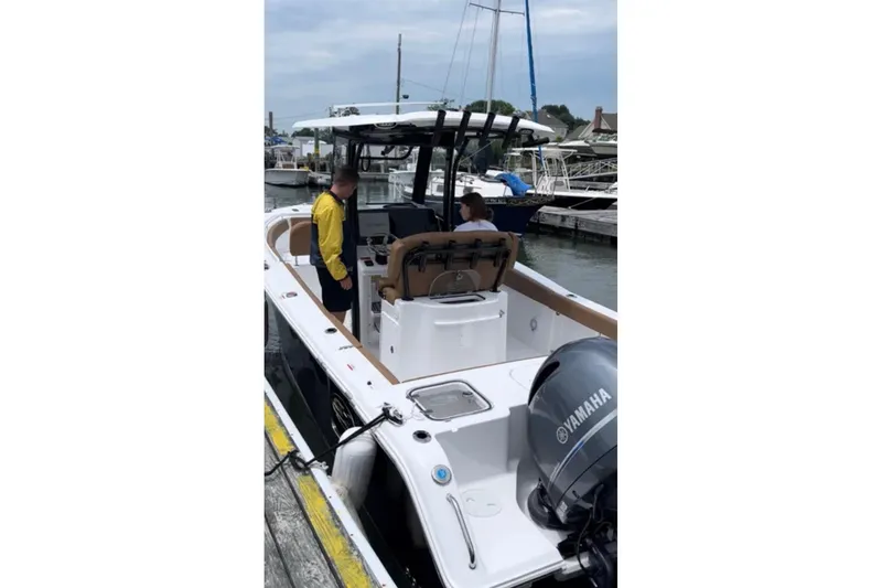 Slide: The Image of 2022 Sea Hunt Gamefish 25 boat docked, featuring Yamaha engine, with two people onboard. - 4