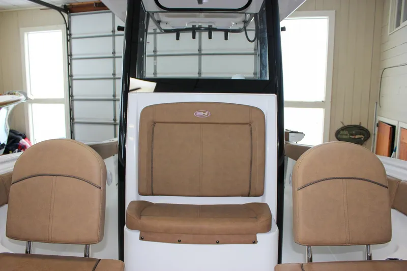 Slide: The Image of 2022 Sea Hunt Gamefish 25 boat interior with tan seating in a garage. - 51