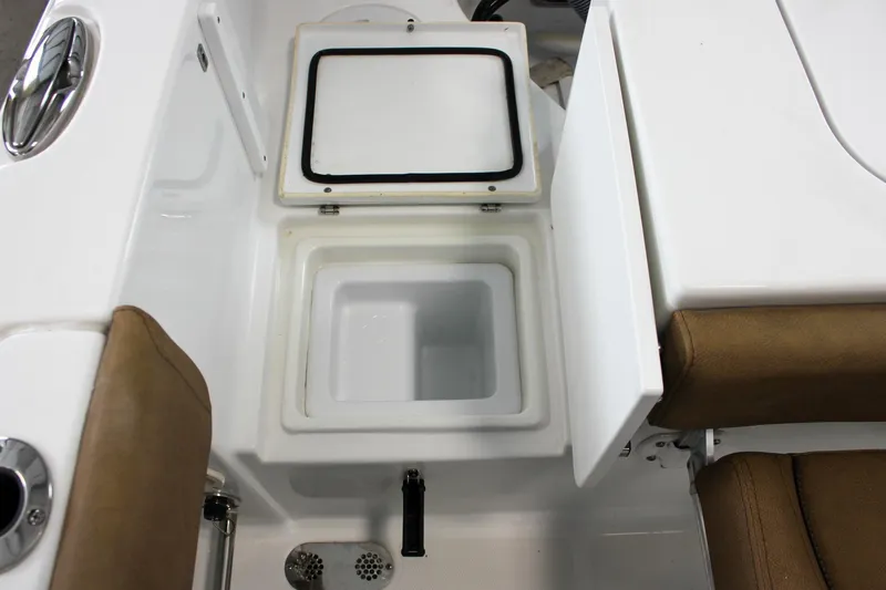 Slide: The Image of Open storage compartment on 2022 Sea Hunt Gamefish 25 boat, featuring white interior and brown seating. - 57