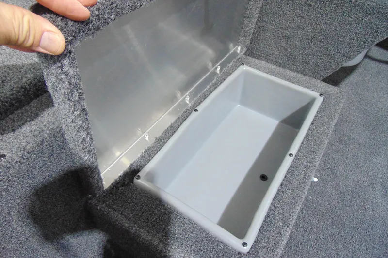 Slide: The Image of Crestliner 1700 Storm 2026 boat storage compartment with carpeted lid open. - 7