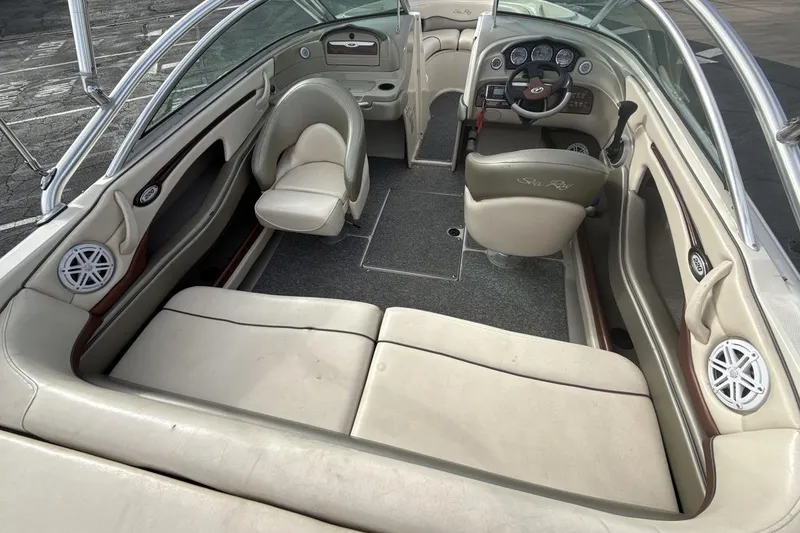 Slide: The Image of 2004 Sea Ray 220 Select boat interior with beige seating and dashboard controls. - 10