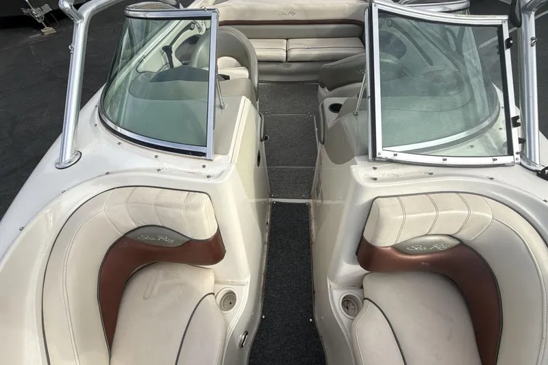 Slide: The Image of 2004 Sea Ray 220 Select boat interior with beige and brown seating, open windshield. - 12