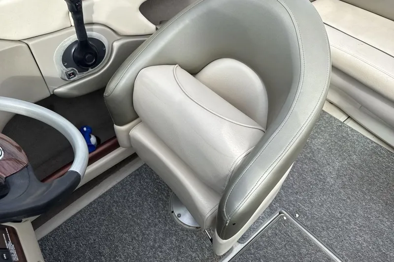 Slide: The Image of 2004 Sea Ray 220 Select boat interior with steering wheel and cushioned seat. - 13