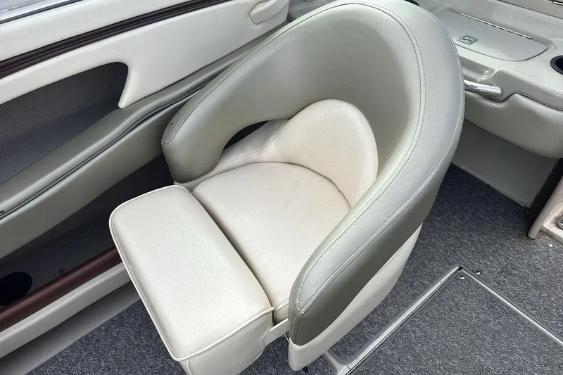 Slide: The Image of 2004 Sea Ray 220 Select boat interior with cushioned seating and carpeted flooring. - 17