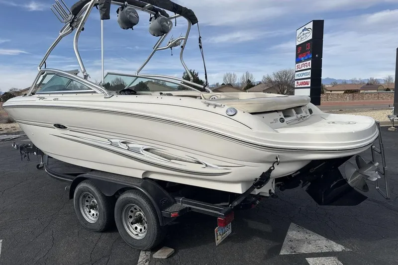 Slide: The Image of 2004 Sea Ray 220 Select boat on trailer, parked outdoors, showcasing sleek design and dual axles. - 3