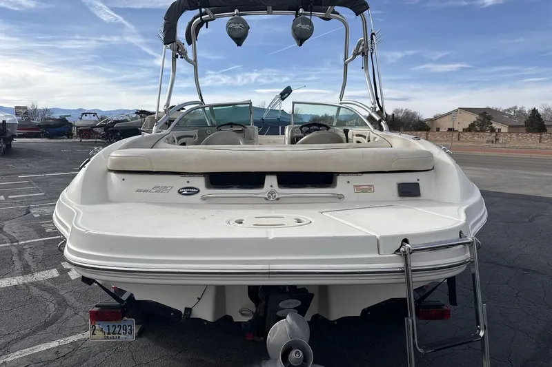Slide: The Image of 2004 Sea Ray 220 Select boat, rear view, parked on asphalt with clear sky background. - 4