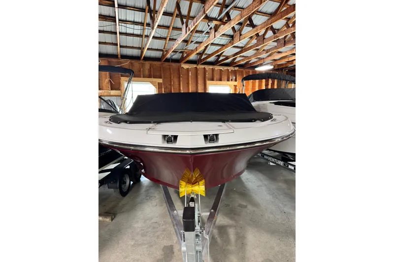 Slide: The Image of 2026 Stingray 20 SBX boat in storage, featuring a sleek design and covered bow. - 9