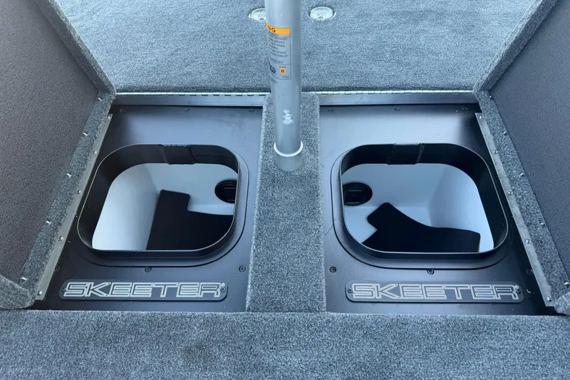 Slide: The Image of 2026 Skeeter FXR20 boat storage compartments with carpeted deck and Skeeter branding. - 11