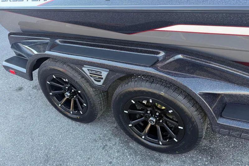 Slide: The Image of 2026 Skeeter FXR20 boat trailer with black alloy wheels on asphalt. - 18