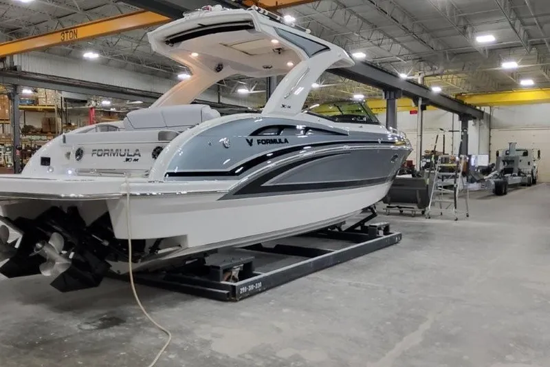 Slide: The Image of 2026 Formula 310 Bowrider I/O boat in a warehouse, showcasing sleek design and modern features. - 2