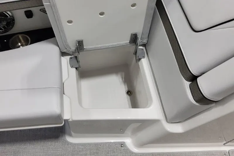 Slide: The Image of 2026 Formula 310 Bowrider I/O boat seat storage compartment, open with white cushioned seating. - 30