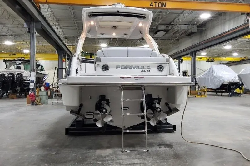 Slide: The Image of 2026 Formula 310 Bowrider I/O boat in a warehouse, rear view with dual propellers. - 5