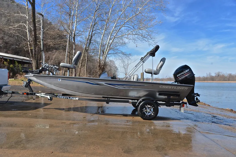 Slide: The Image of 2017 Crestliner VT 17 fishing boat on trailer by a lake, under clear blue sky. - 11
