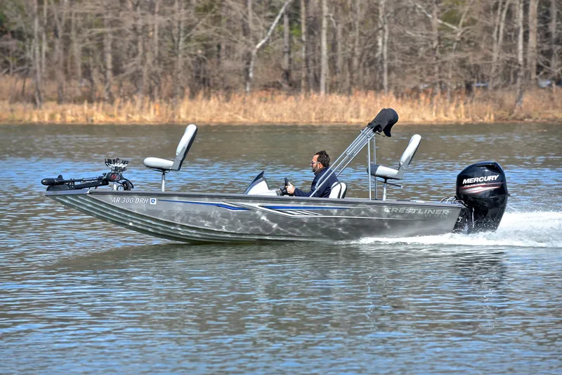 Slide: The Image of 2017 Crestliner VT 17 boat cruising on a lake with a Mercury outboard motor. - 2