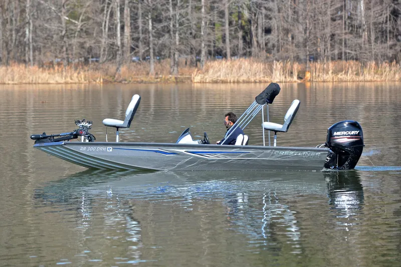 Slide: The Image of 2017 Crestliner VT 17 boat on a calm lake with trees in the background. - 9