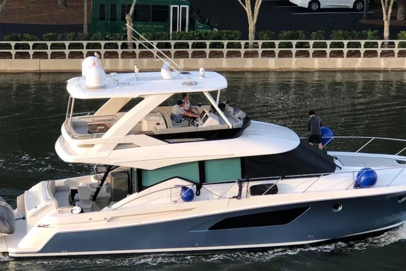 The Image of 2019 Tiara Yachts F53 Flybridge cruising on a calm waterway. - 0