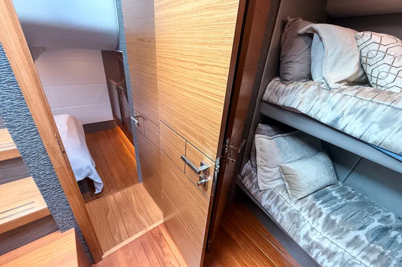 Slide: The Image of 2019 Tiara Yachts F53 Flybridge interior with cozy bunk beds and wooden flooring. - 100
