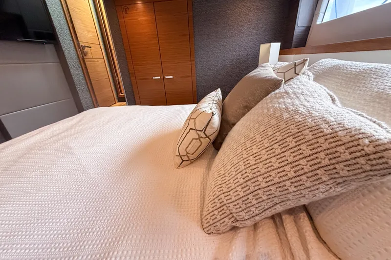 Slide: The Image of Luxurious bedroom interior of 2019 Tiara Yachts F53 Flybridge with plush bedding and wooden accents. - 107