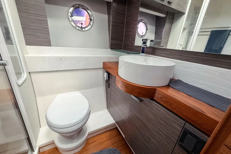 Slide: The Image of Luxurious 2019 Tiara Yachts F53 Flybridge bathroom with modern fixtures and elegant wood accents. - 109