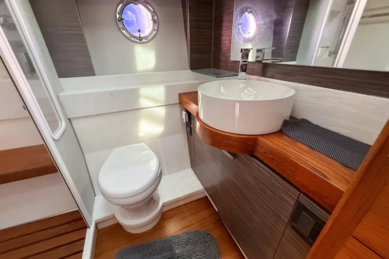 Slide: The Image of Luxurious bathroom in 2019 Tiara Yachts F53 Flybridge with modern fixtures and porthole window. - 113