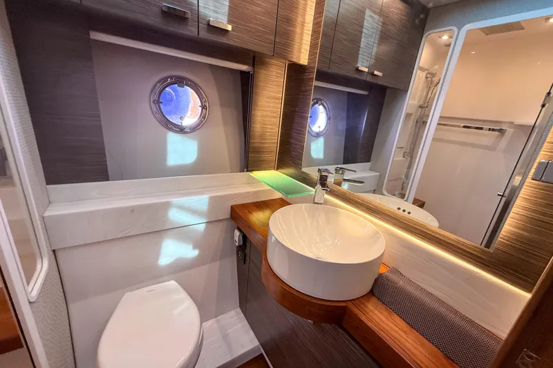 Slide: The Image of Luxurious bathroom in 2019 Tiara Yachts F53 Flybridge with modern fixtures and porthole window. - 117