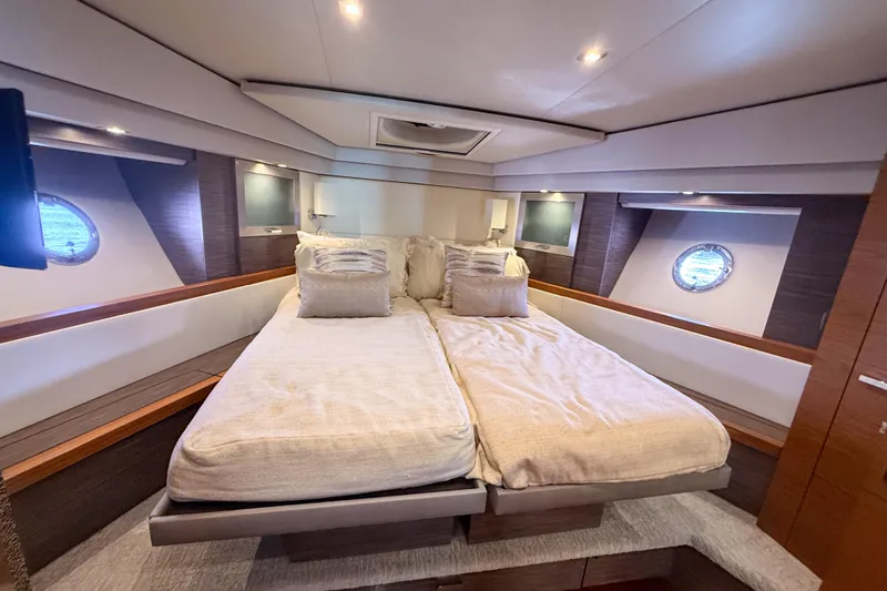 Slide: The Image of Luxurious bedroom interior of 2019 Tiara Yachts F53 Flybridge with elegant bedding and porthole windows. - 119